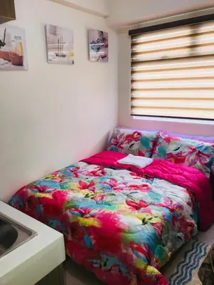 a bedroom with a bed with a colorful comforter at Shanilyn Residency Urban Deca Towers EDSA mandaluyong Unlimited INTERNET AND NETFLIX in Manila