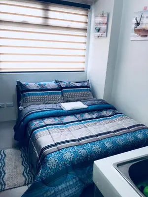 a bed sitting in a room next to a window at Shanilyn Residency Urban Deca Towers EDSA mandaluyong Unlimited INTERNET AND NETFLIX in Manila