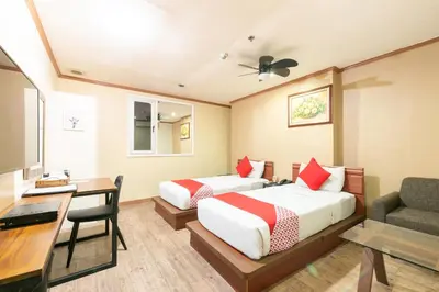 a hotel room with two beds and a desk and a chair at DG Grami Hotel in Manila