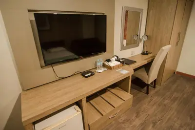 a room with a desk with a large television on the wall at DG Grami Hotel in Manila