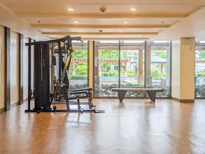 a gym with a machine and a bench in a room at Studio Condo NAIA Airport Terminal 3 Newport City Casino in Manila