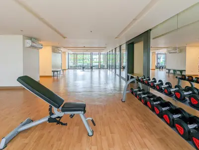 an empty gym with a bench and dumbbells at Studio Condo NAIA Airport Terminal 3 Newport City Casino in Manila