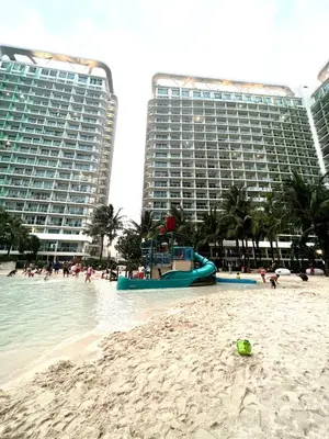 a beach with a slide in the water and buildings at Azure Urban Resort Residences, Condo, Manila Airport, Wave-Pool, Tropical Vibe in Manila
