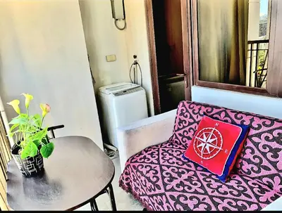 a room with a couch and a table with a pillow at 1BR Near Beach, Airport & In City of Manila Bay in Manila