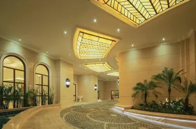 a large lobby with palm trees in a building at 1BR Near Beach, Airport & In City of Manila Bay in Manila