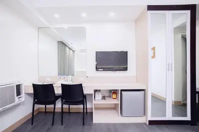 a room with a table with two chairs and a tv at The Charter House in Manila