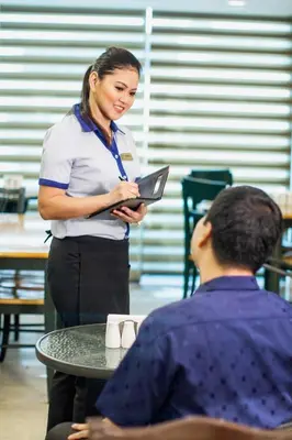 a woman standing in front of a table with a laptop at The Charter House in Manila