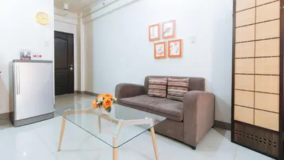 a living room with a couch and a glass table at RedDoorz at Kassel Residences Parañaque in Manila