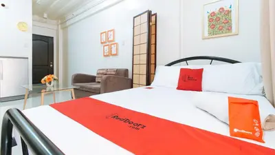 a bedroom with a bed with white and red pillows at RedDoorz at Kassel Residences Parañaque in Manila