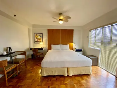 a bedroom with a bed and a desk and a table at The Clipper Hotel, Poblacion Makati in Manila