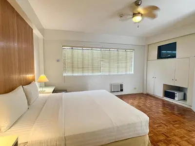 a bedroom with a large white bed and a window at The Clipper Hotel, Poblacion Makati in Manila