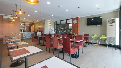 a restaurant with tables and chairs and a clock on the wall at RedDoorz Plus at MM Hotel Las Pinas former RedDoorz Plus Near Bamboo Organ in Manila