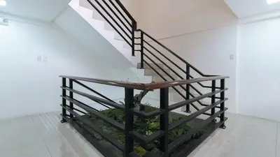 a staircase in a house with a plant at RedDoorz Plus at Evangelista Street Makati in Manila