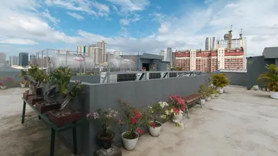 a balcony with potted plants and buildings in the background at RedDoorz Plus at Evangelista Street Makati in Manila