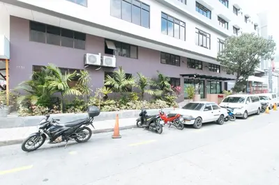 a row of motorcycles parked in front of a building at RedDoorz Plus at Evangelista Street Makati in Manila