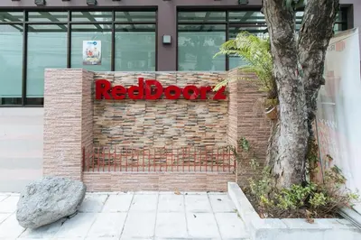a redbox sign on a brick wall in front of a building at RedDoorz Plus at Evangelista Street Makati in Manila