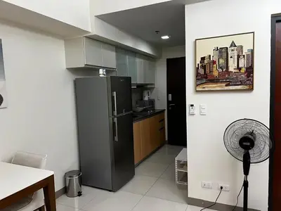 a kitchen with a black refrigerator in a room at ONE UPTOWN RESIDENCE in Manila