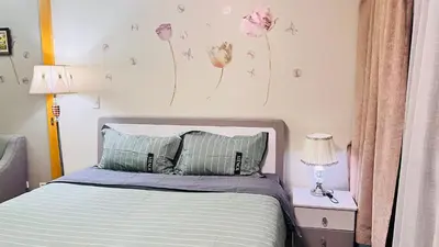 a bedroom with a bed with flowers on the wall at ONE UPTOWN RESIDENCE in Manila