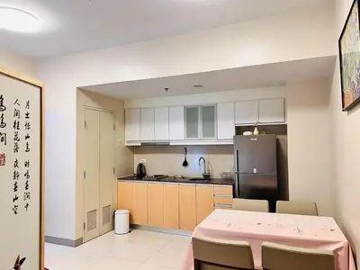 a kitchen with a table and a refrigerator at ONE UPTOWN RESIDENCE in Manila
