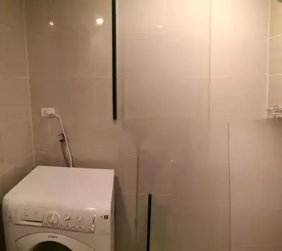 a small bathroom with a washing machine in it at ONE UPTOWN RESIDENCES in Manila
