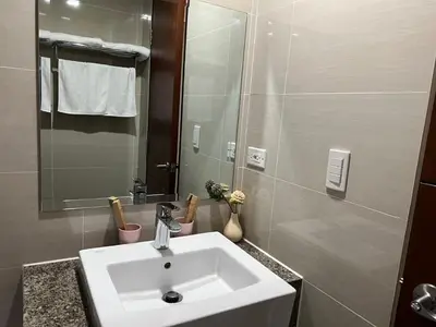 a bathroom with a sink and a mirror at ONE UPTOWN RESIDENCES in Manila