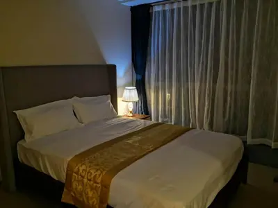 a bedroom with a large bed with a window at ONE UPTOWN RESIDENCES in Manila