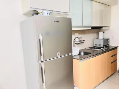a stainless steel refrigerator in a small kitchen at ONE UPTOWN residence SW14M 9TH AVENUE ST \u516c\u5bd3 in Manila