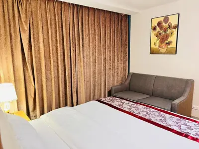 a bedroom with a bed and a couch in front of a window at ONE UPTOWN residence SW14M 9TH AVENUE ST \u516c\u5bd3 in Manila