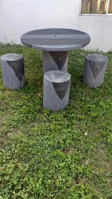 a table with two stone stools in the grass at Mia and Miguel's House in General Trias