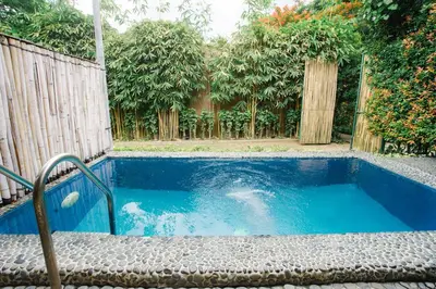 a swimming pool in the middle of a garden at The Park - Silang in Silang