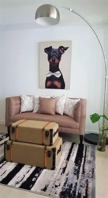 a living room with a couch and a painting of a dog at AZURE Urban Resort Residences 1BR Condo with huge wavepool & man-made beach near Airport in Manila