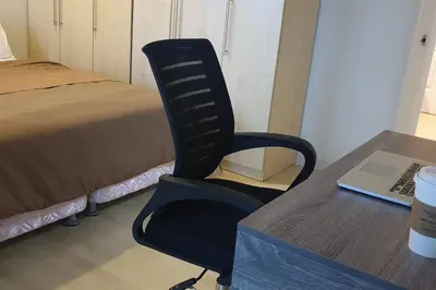 a black chair sitting next to a desk with a laptop at MANDALUYONG 2 Br w 2 Queen, 50HDtv across Shangrila Mall in Manila