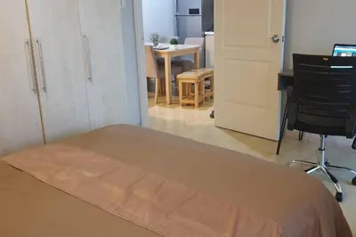 a bedroom with a bed and a desk and a chair at MANDALUYONG 2 Br w 2 Queen, 50HDtv across Shangrila Mall in Manila