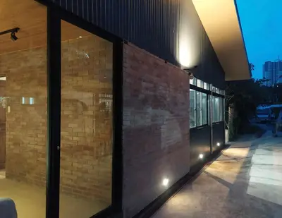 a brick building with large glass windows on it at The Hub District Garden Suites in Manila