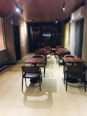 a row of tables and chairs in a room at The Hub District Garden Suites in Manila