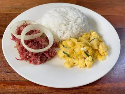 a white plate of food with rice and meat at The Hub District Garden Suites in Manila