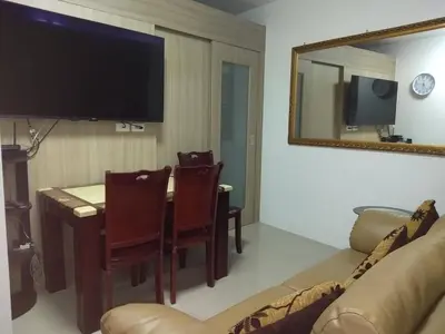 a living room with a table and a couch and a mirror at Jones Shore Residences in Manila