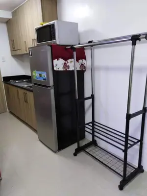 a kitchen with a microwave on top of a refrigerator at Jones Shore Residences in Manila