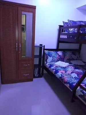 a bedroom with two bunk beds and a cabinet at Jones Shore Residences in Manila
