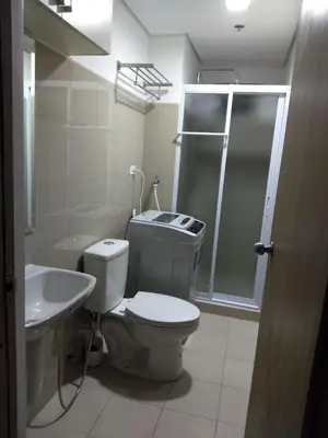 a bathroom with a toilet and a sink and a shower at Jones Shore Residences in Manila