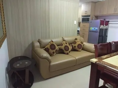 a living room with a couch with pillows on it at Jones Shore Residences in Manila