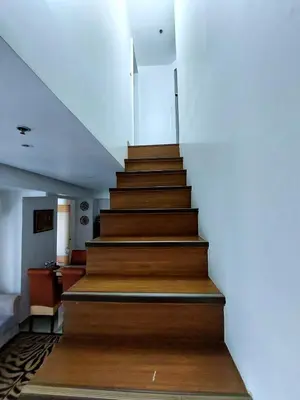 a stairway with wooden steps in a building at Fort Victoria BGC 2 Bedrooms in Manila