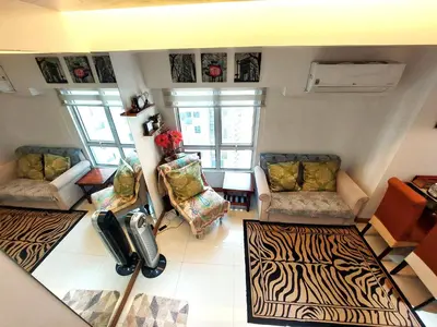 a living room with two chairs and a zebra rug at Fort Victoria BGC 2 Bedrooms in Manila
