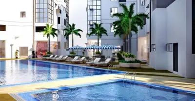 a large swimming pool in the middle of a building at Fort Victoria BGC 2 Bedrooms in Manila
