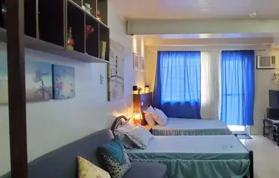 a living room with two beds and a couch at Jen's Apartment in Manila