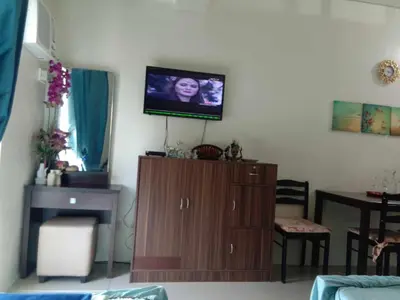 a living room with a tv on a wall at Jen's Apartment in Manila