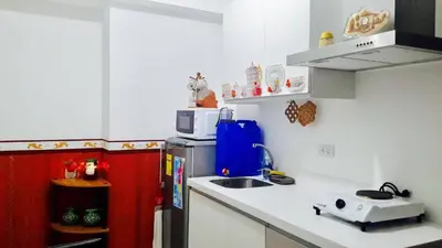 a small kitchen with a sink and a microwave at Azure C3 Balcony Wifi near mall airport in Manila