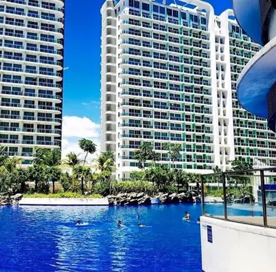 a swimming pool in front of two tall buildings at Azure C3 Balcony Wifi near mall airport in Manila