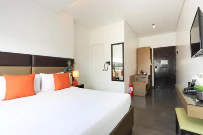 a bedroom with a large bed and a desk at Privato Makati in Manila