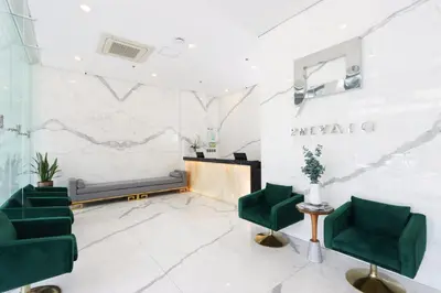 a waiting room with green chairs and a couch at Privato Makati in Manila
